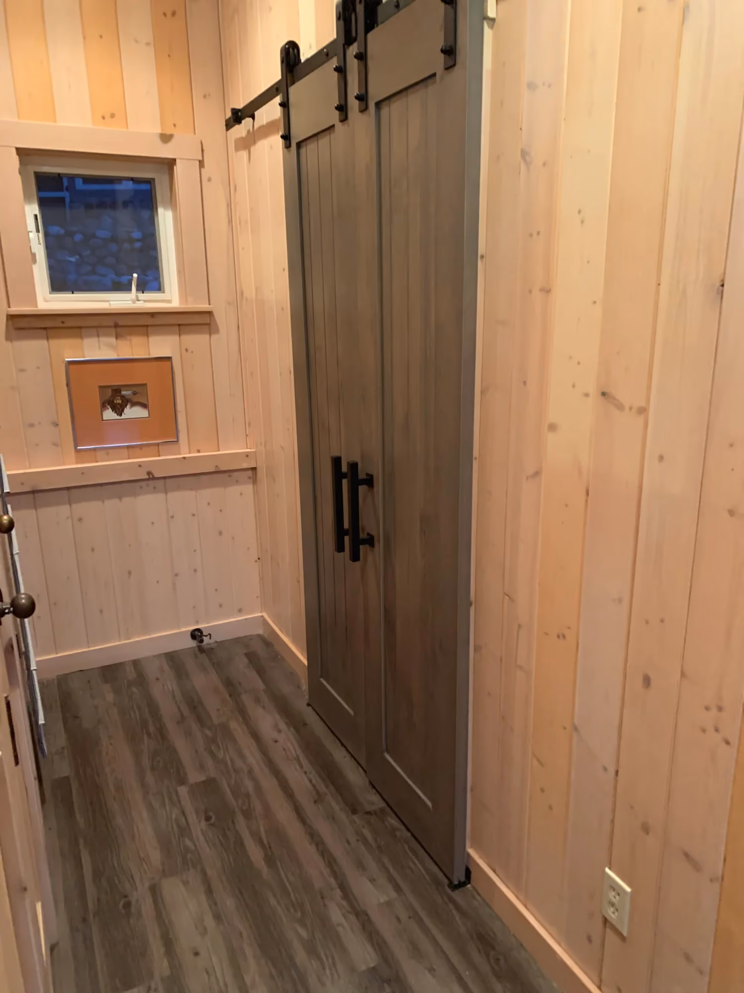 Bathroom doorway view with toilet and wood paneling