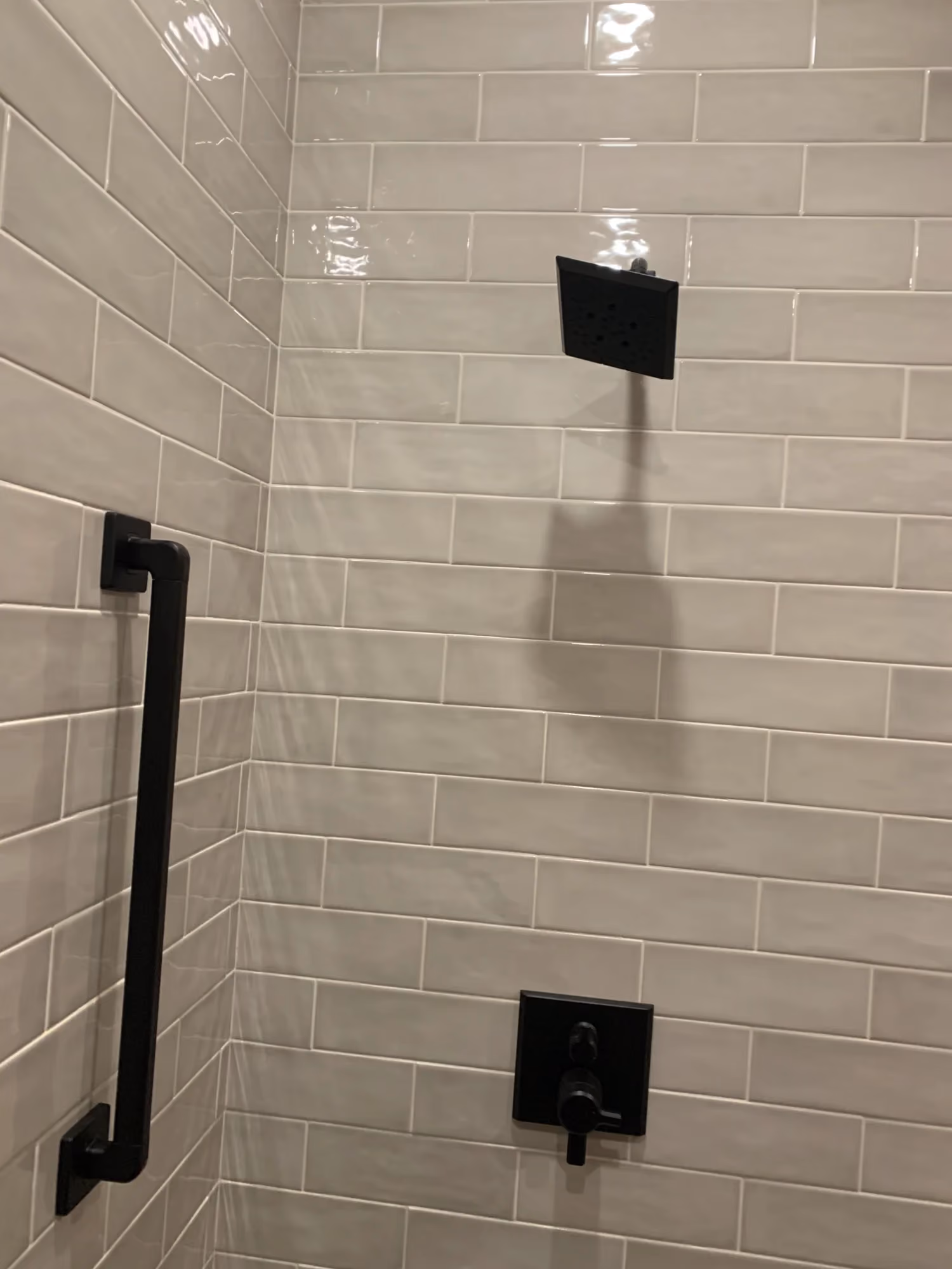 Close-up of shower wall with black fixtures