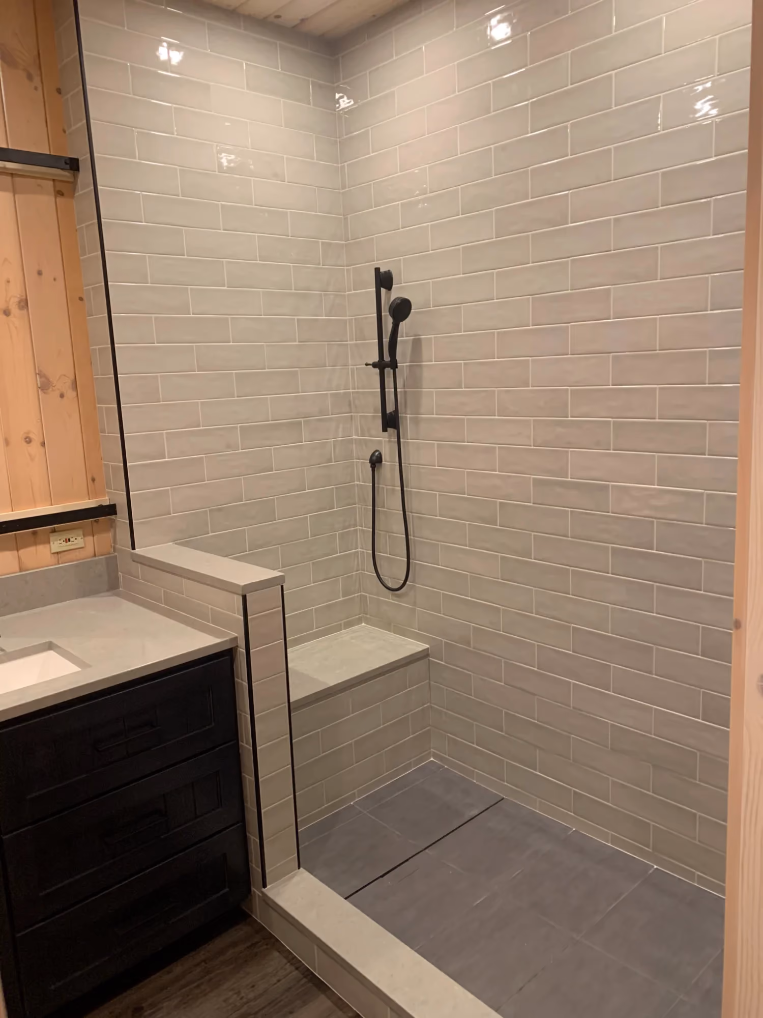 Walk-in shower with tiled walls and black showerhead