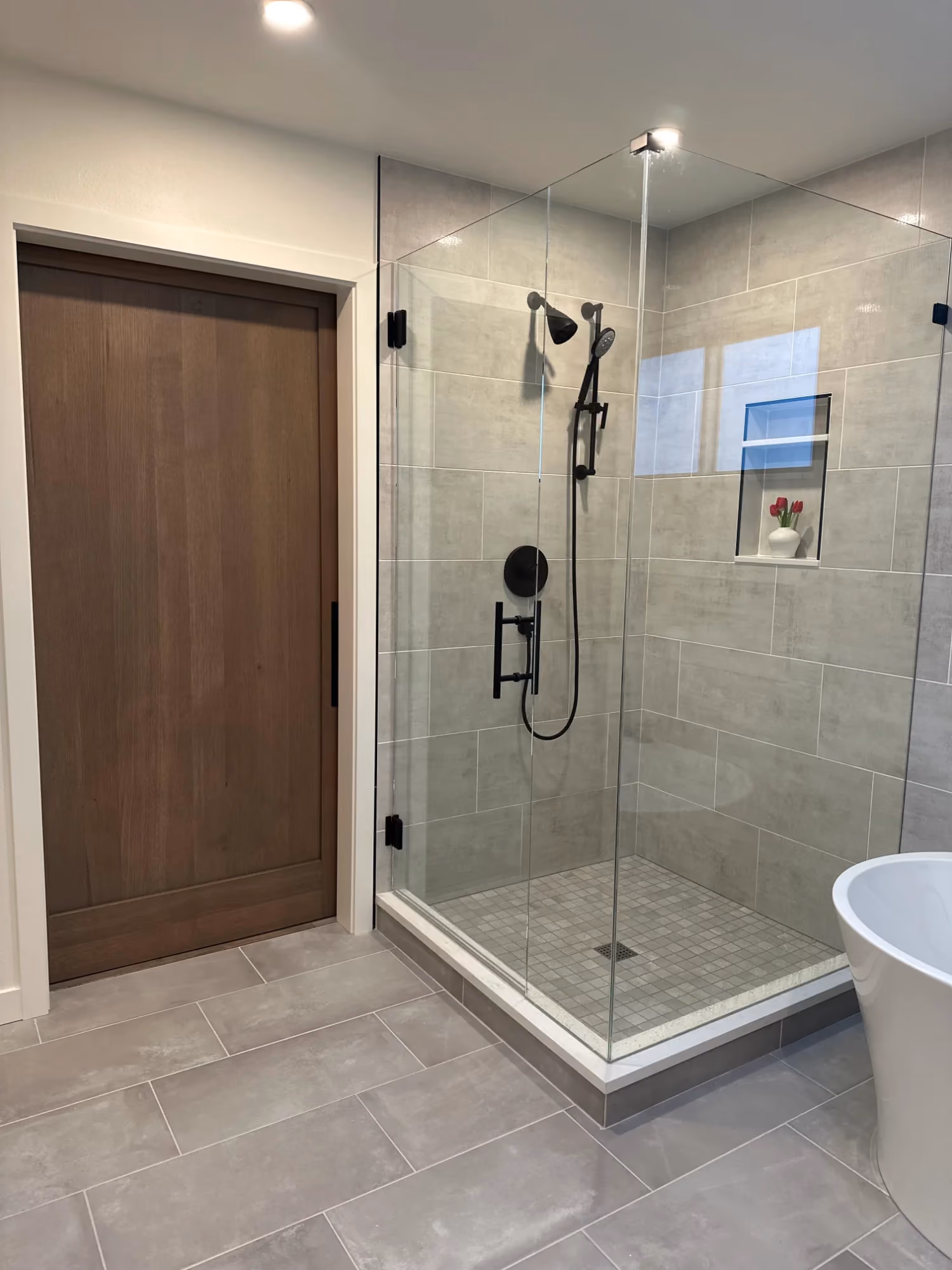 Bathroom with glass shower and wood door