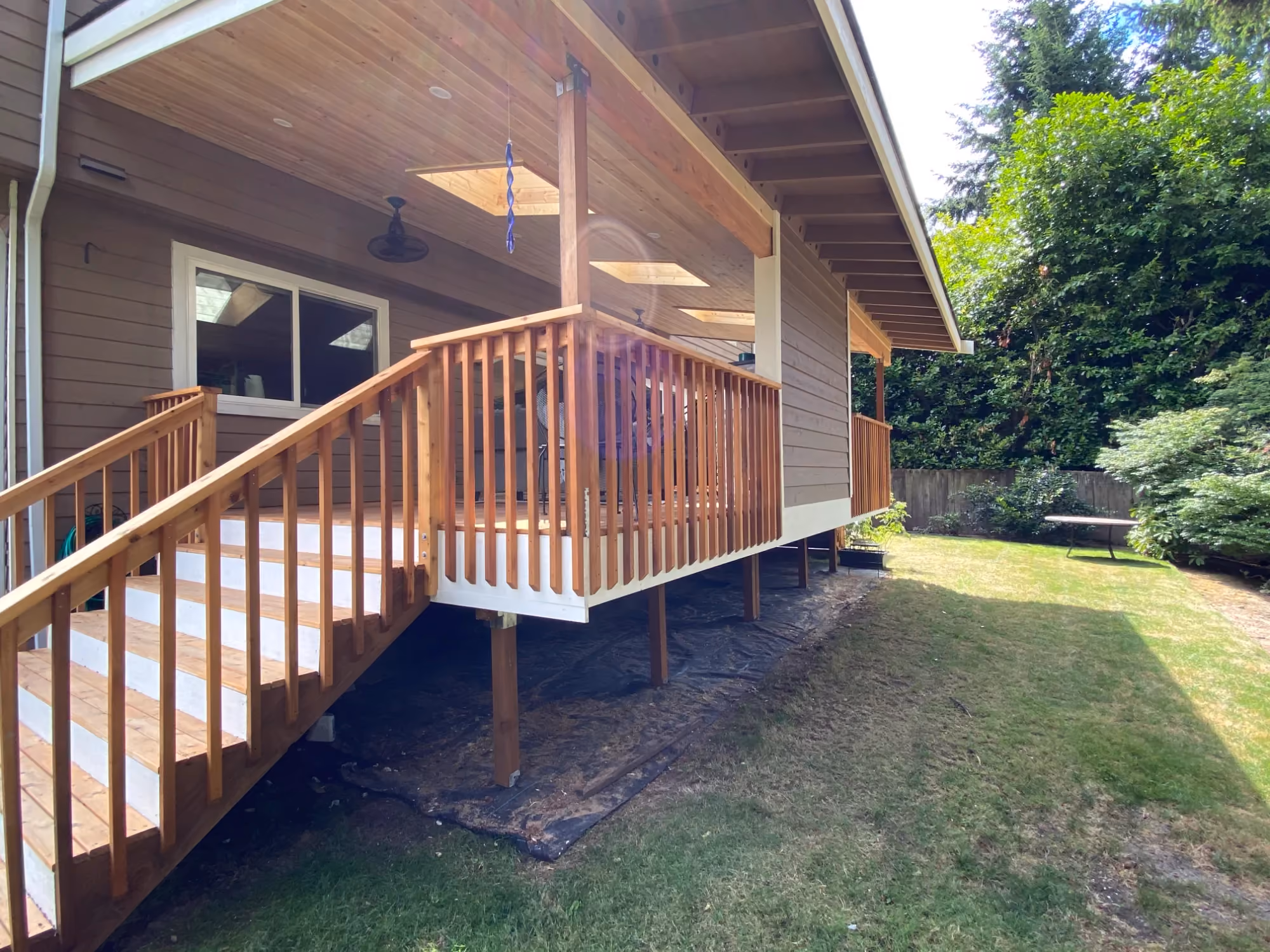 Wooden deck stairs with railing beside a house