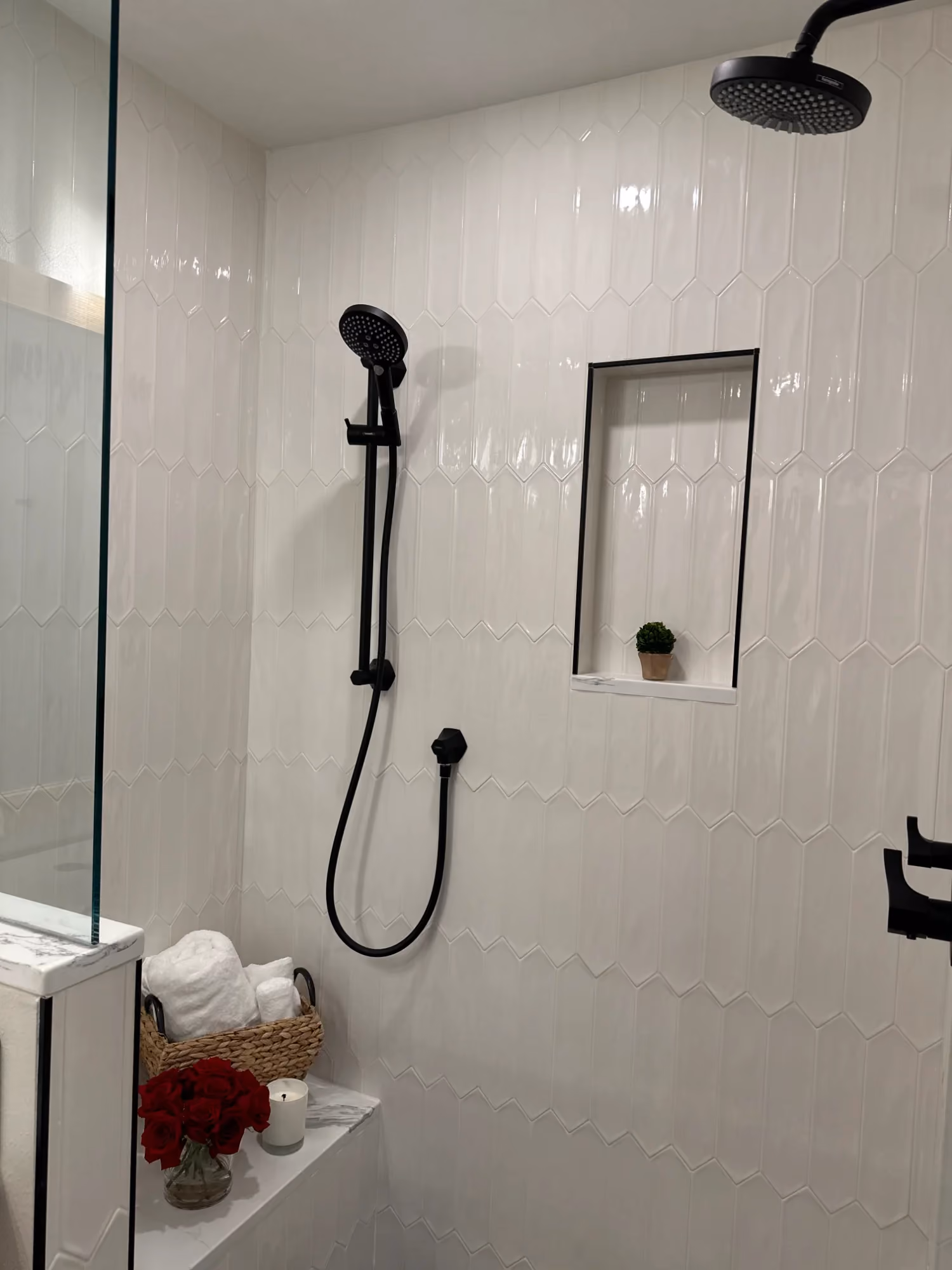 White tiled shower with handheld showerhead