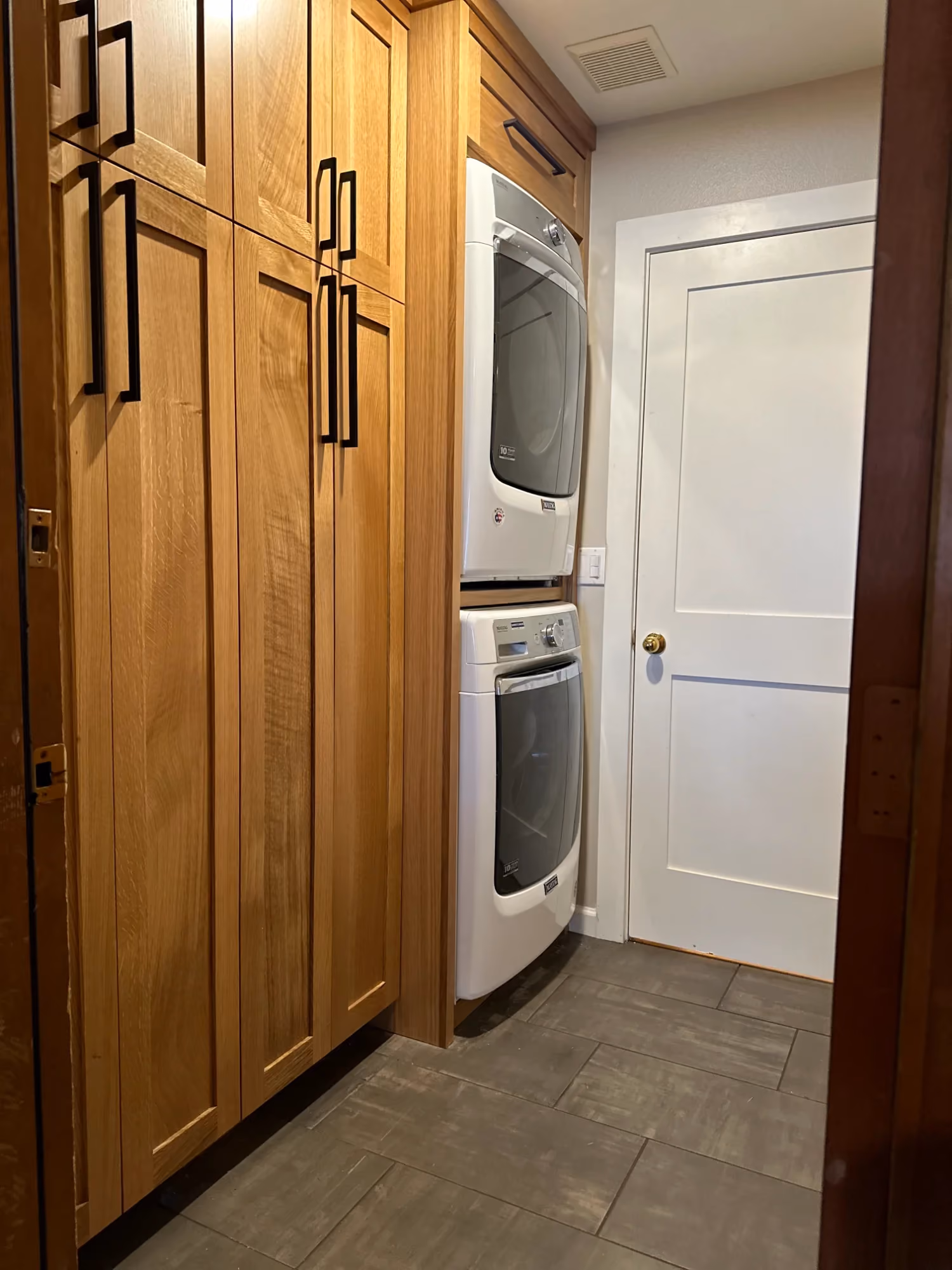 Hallway with wooden cabinets and a white door