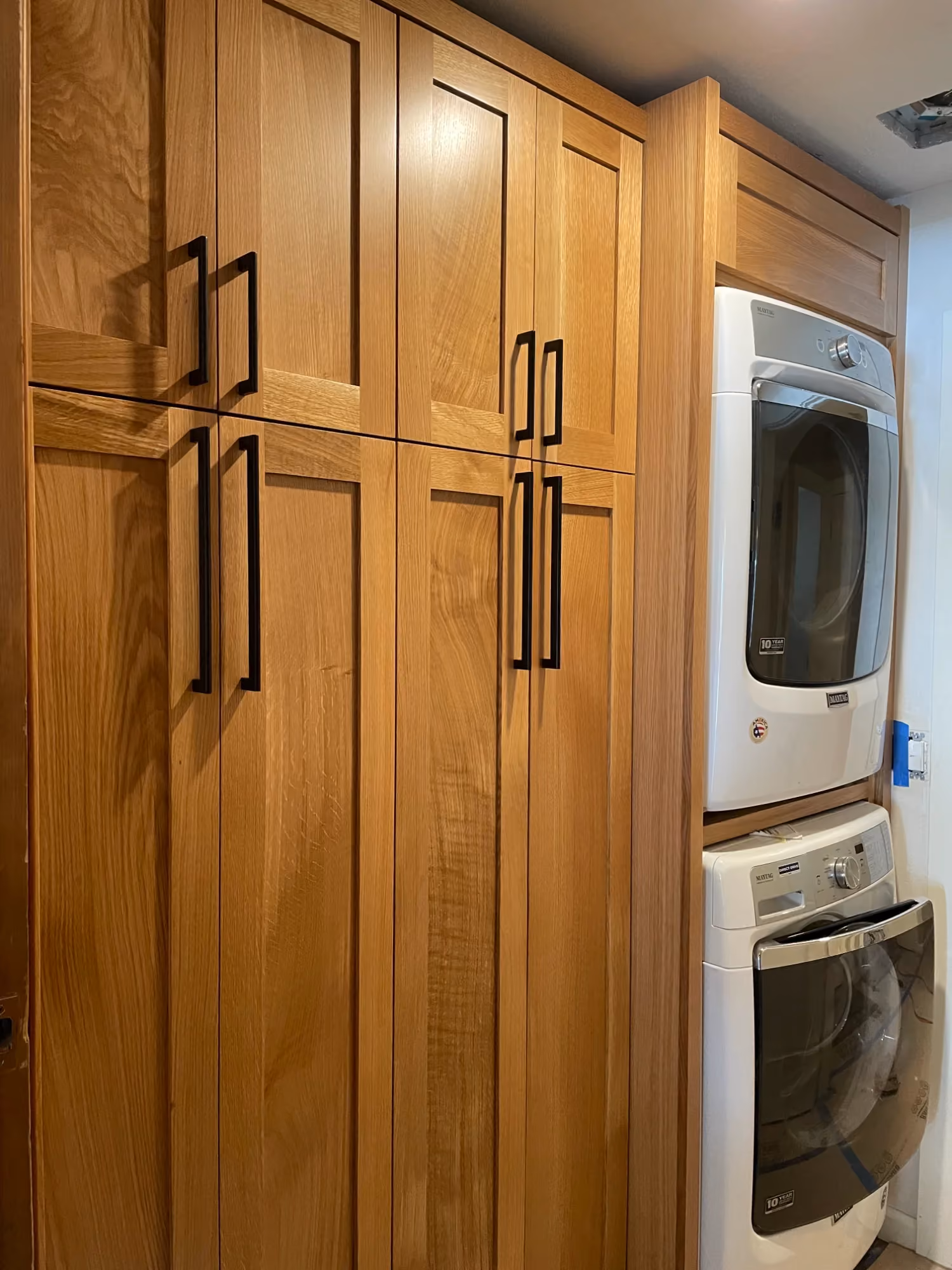 Wooden cabinets with stacked washer and dryer
