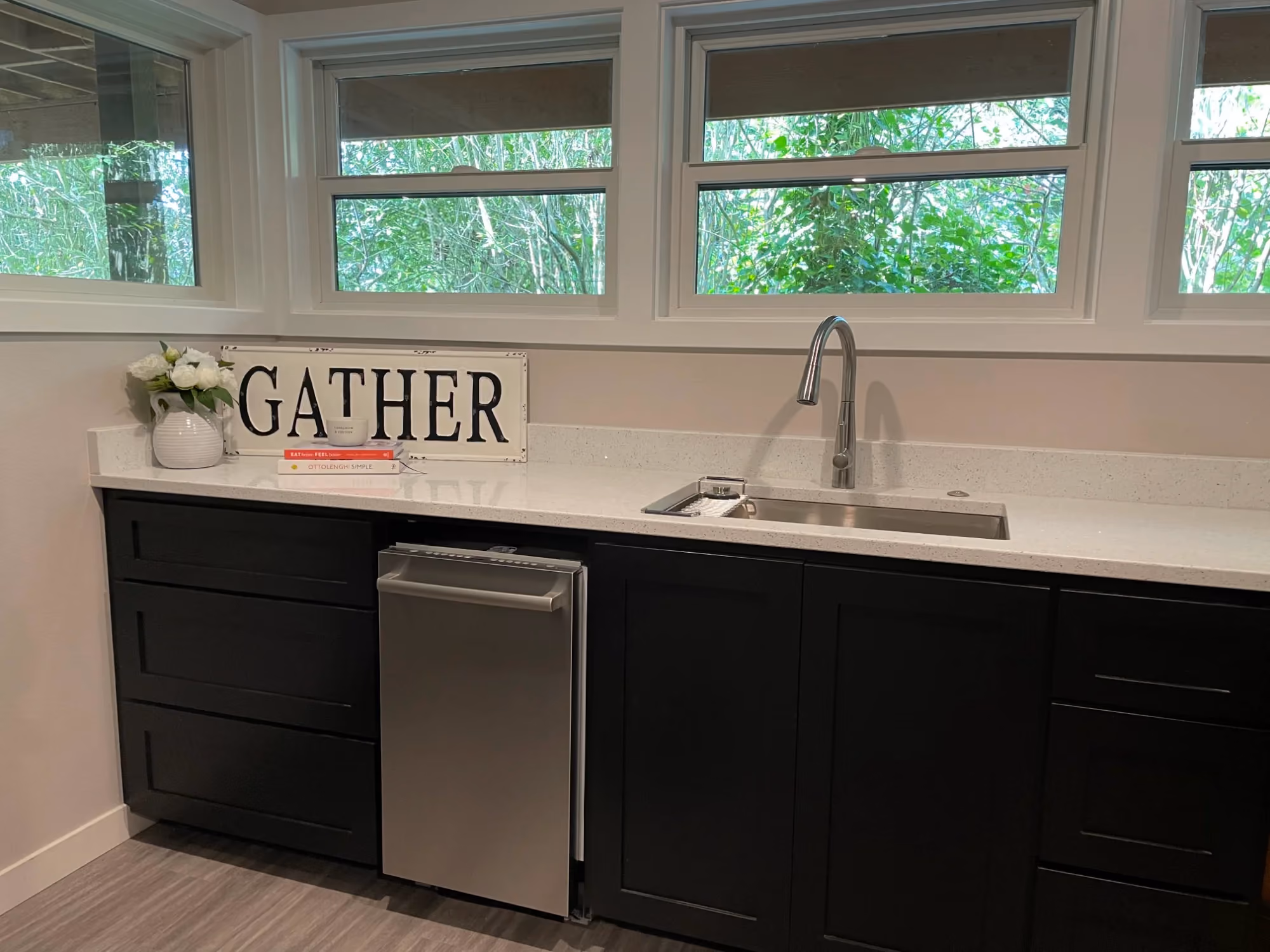 Black kitchen cabinets with sink under window