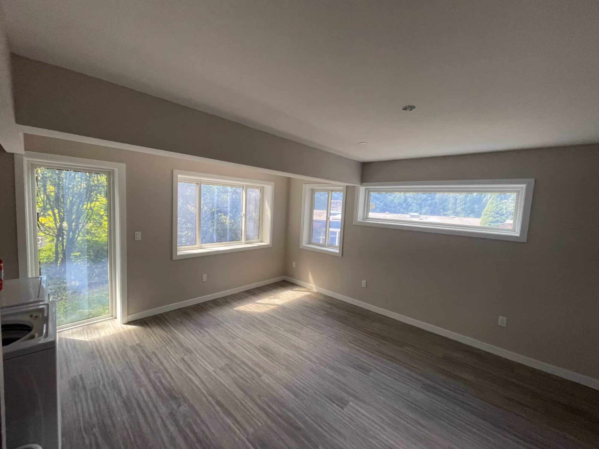 Empty room with large windows and carpeted floor