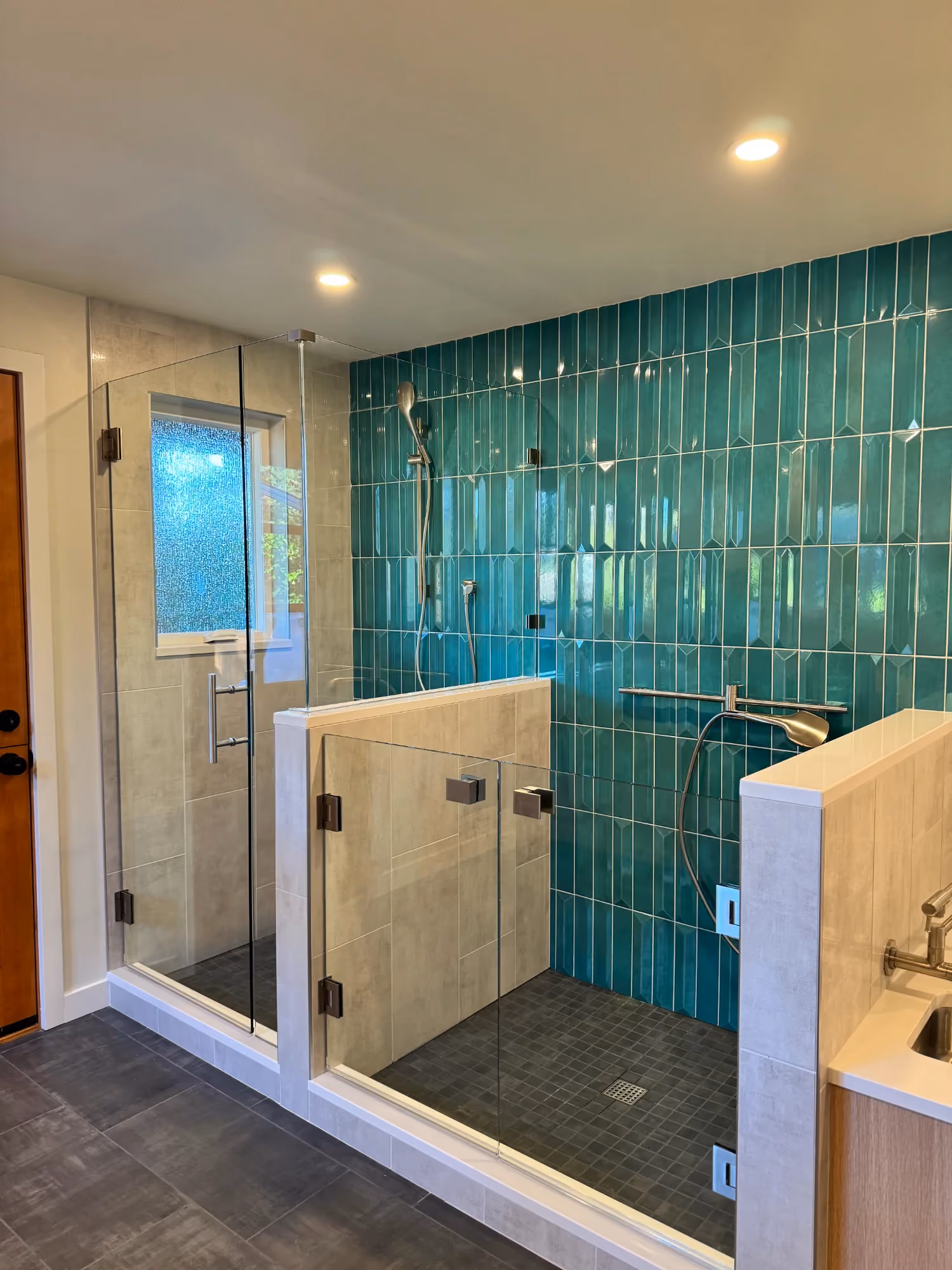 Bathroom with glass shower and teal tiled wall