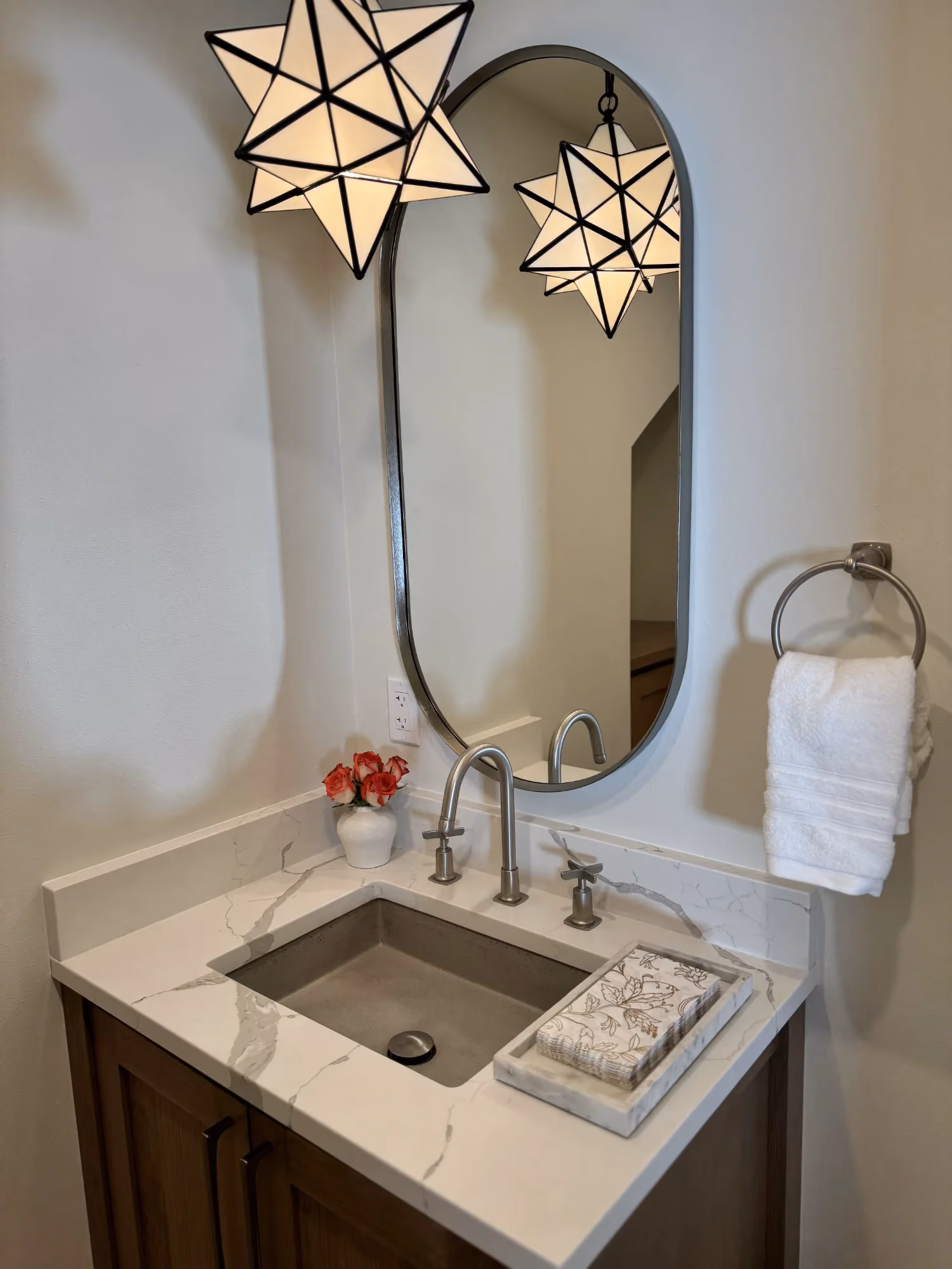 Powder room vanity with mirror and wall-mounted light fixture
