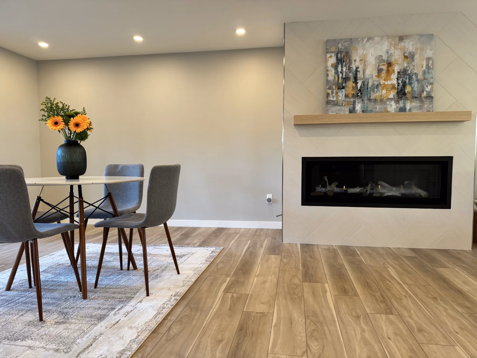 Dining area with table and chairs beside a fireplace