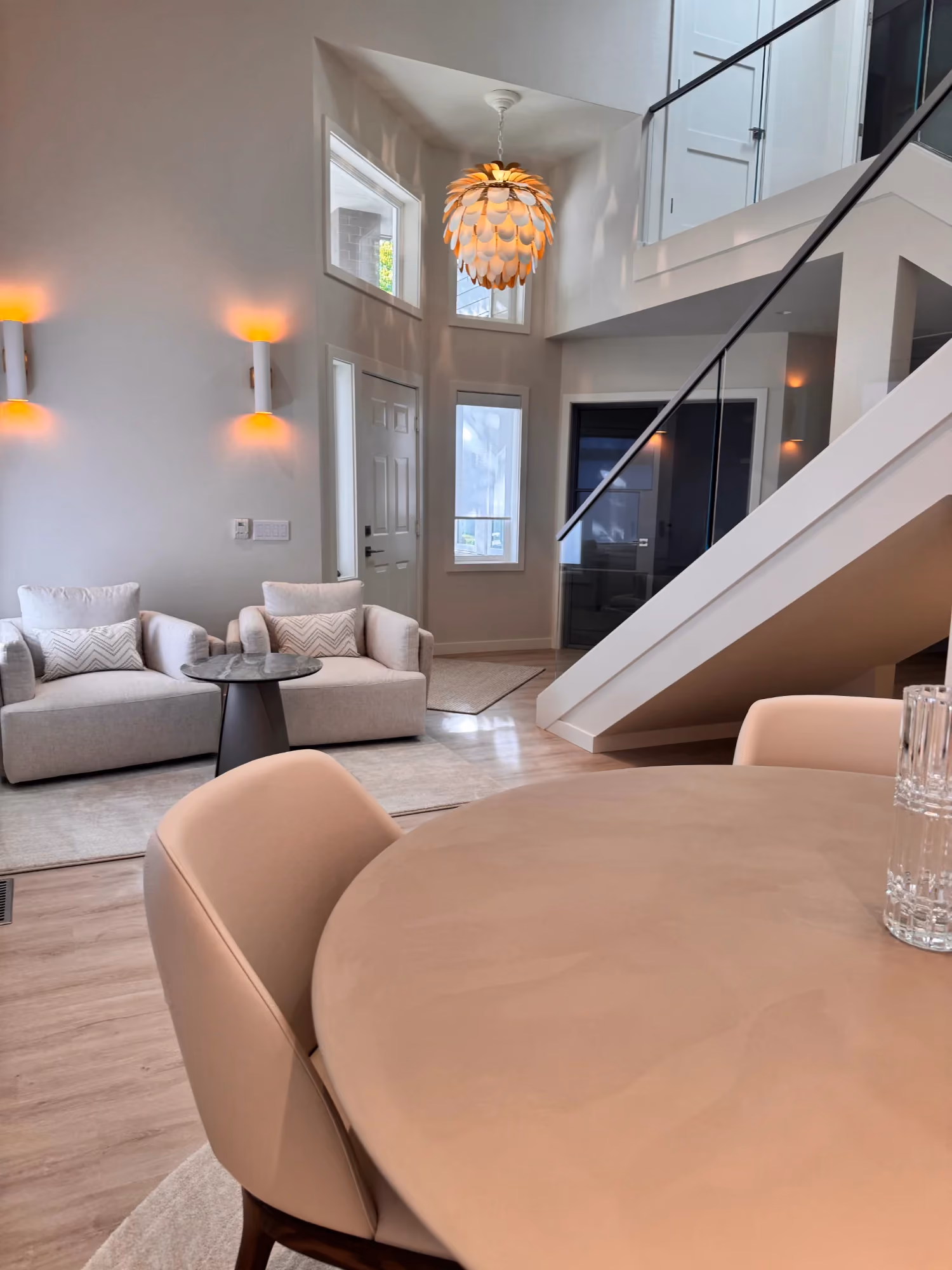 Living room view with staircase and large windows