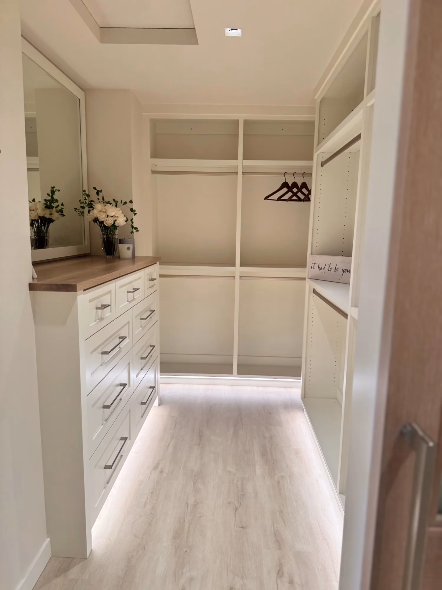 Narrow hallway with light flooring and built-in shelving