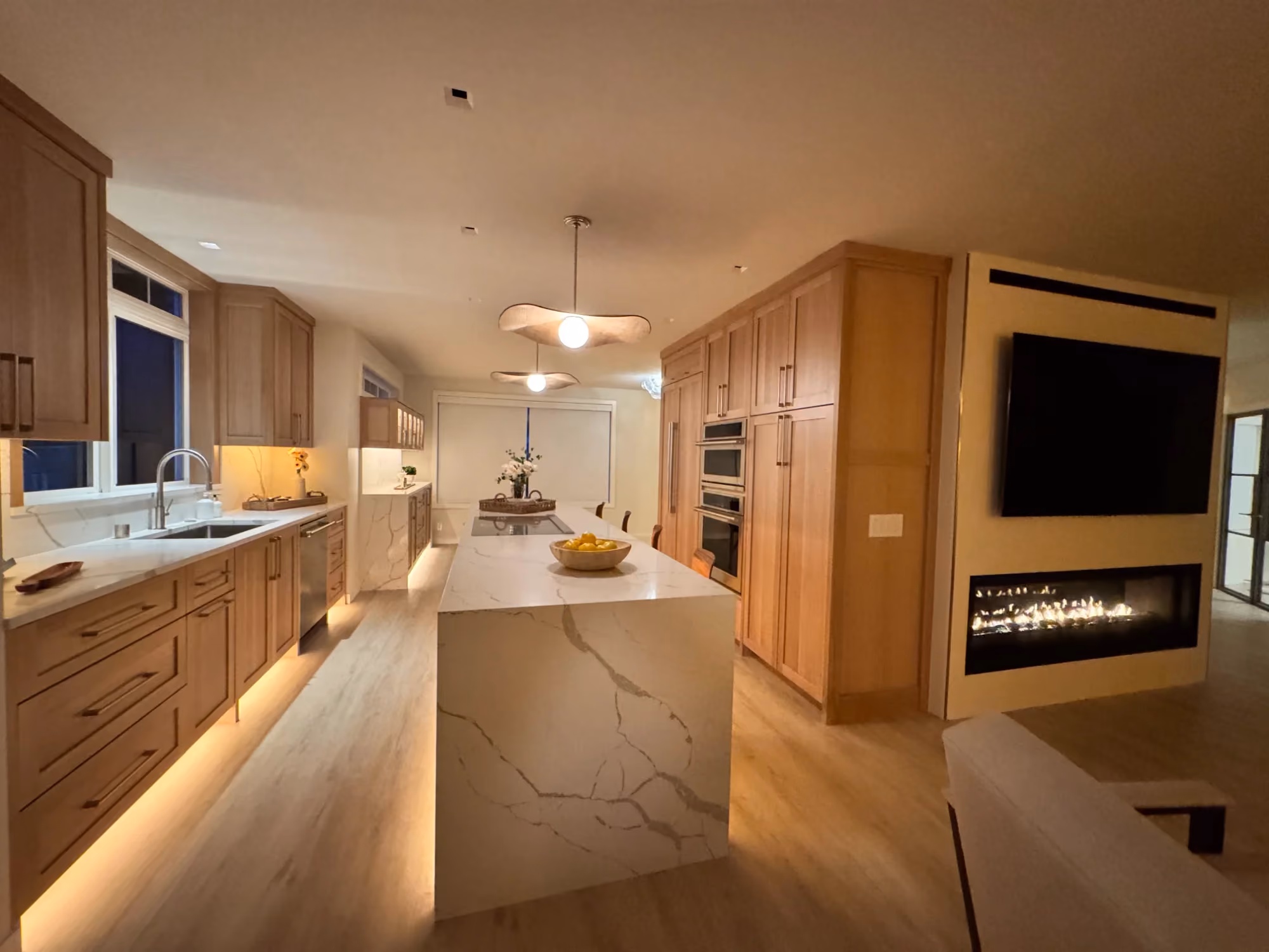 Wide kitchen view with island and built-in appliances