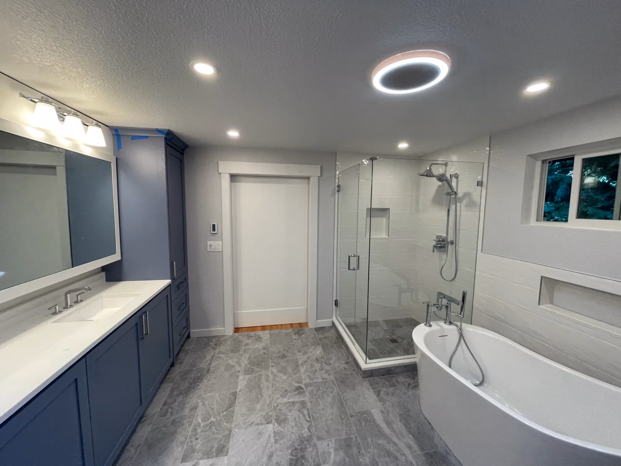 Contemporary bathroom with double vanity and tub