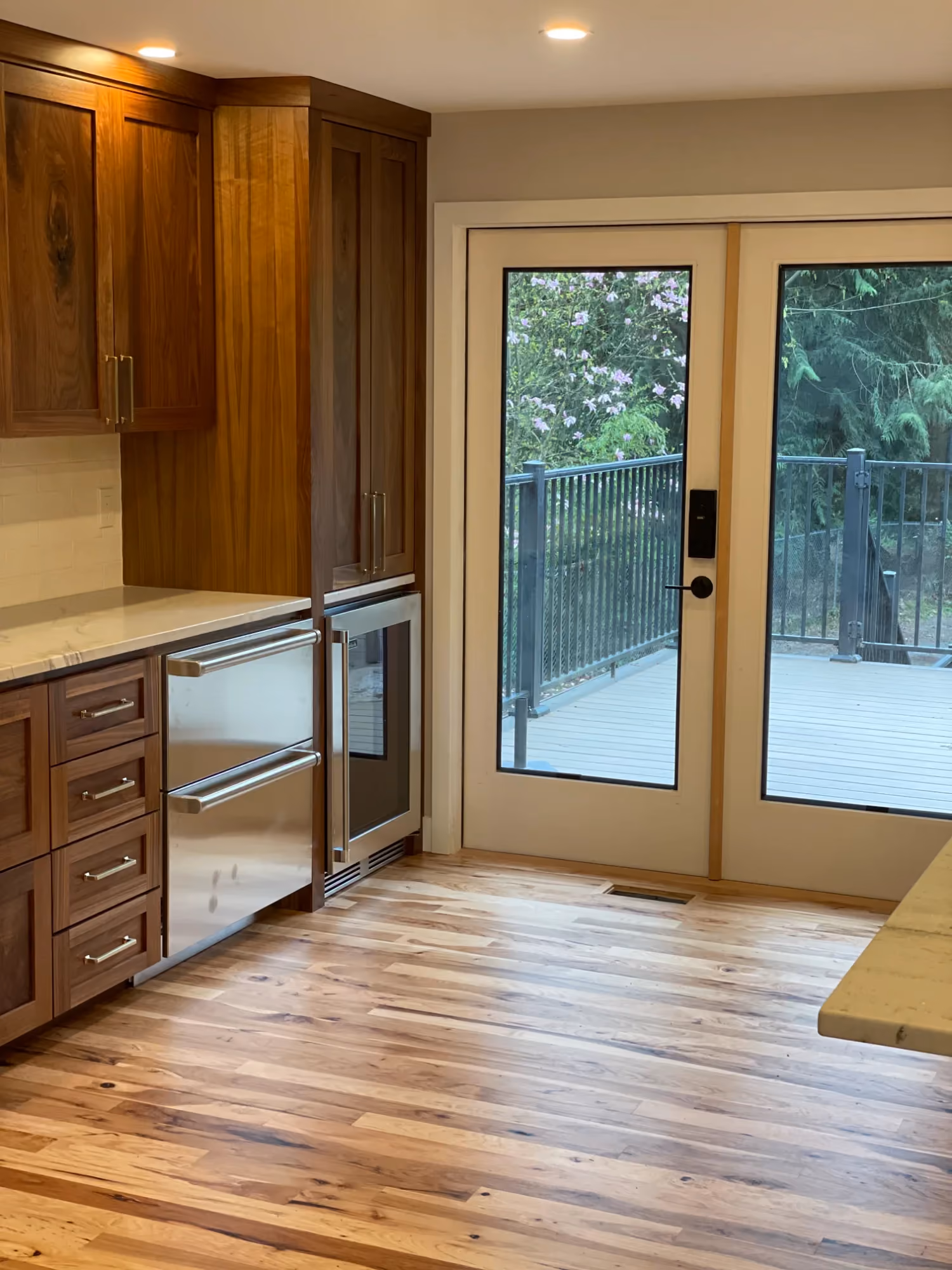 Kitchen corner with wood cabinets, hardwood floor, and glass door
