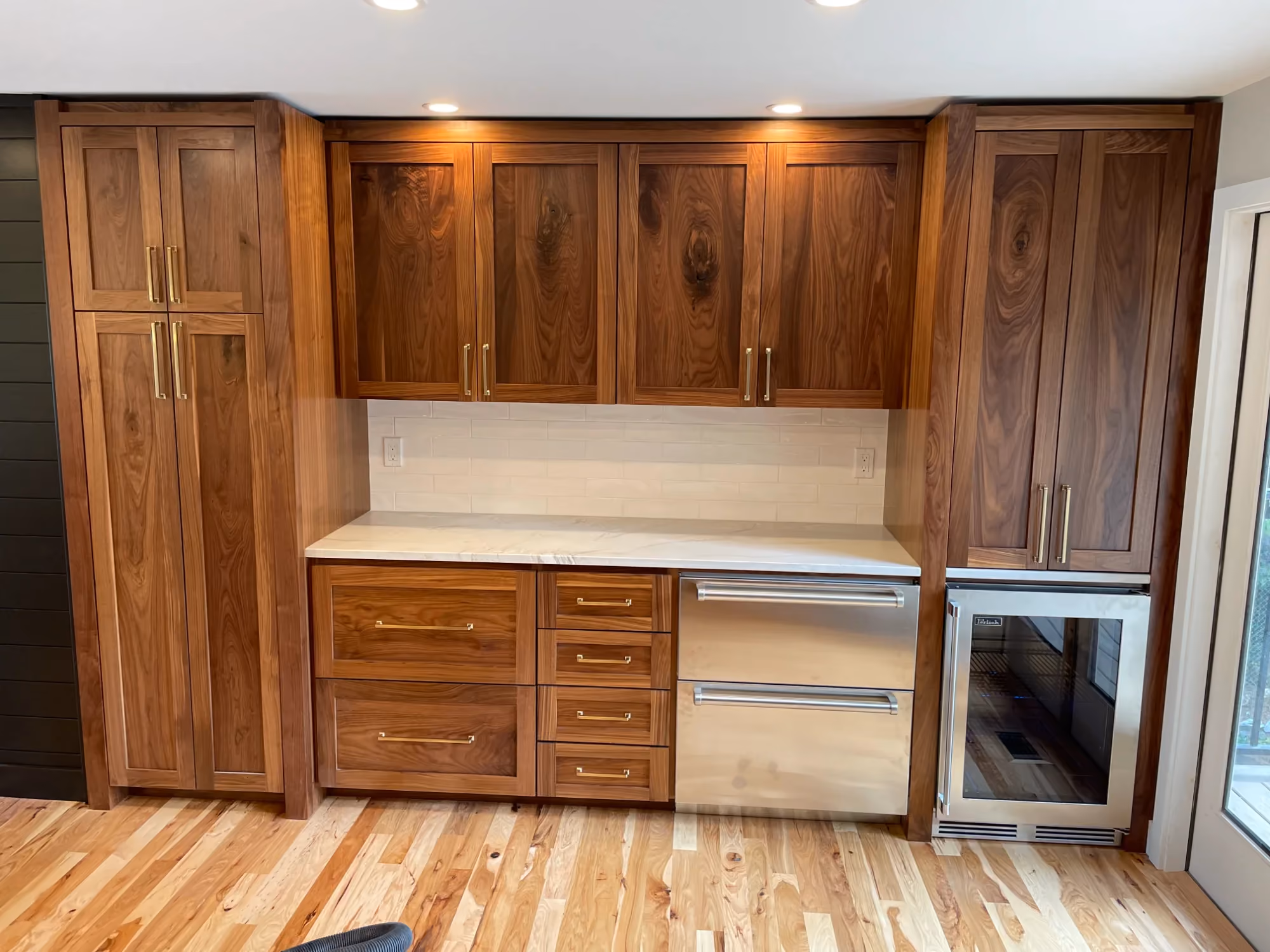 Wall of wooden kitchen cabinets with white counter and oven
