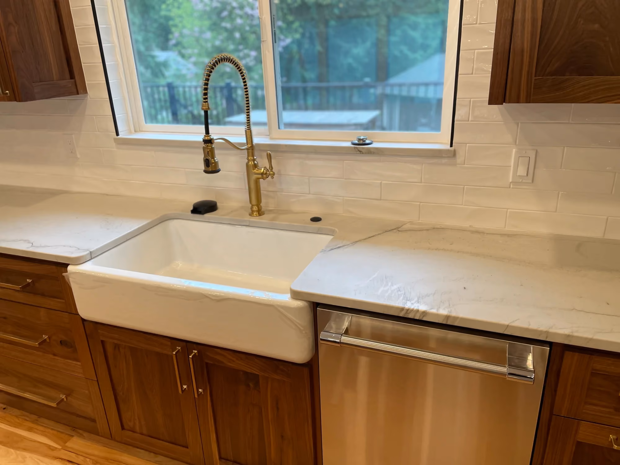 White farmhouse sink set in a light countertop