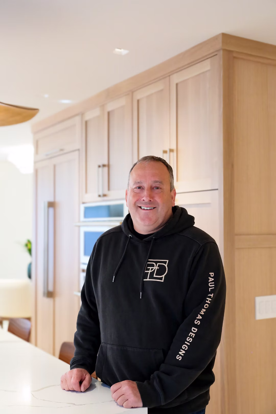 Man standing in unfinished doorway wearing black hoodie