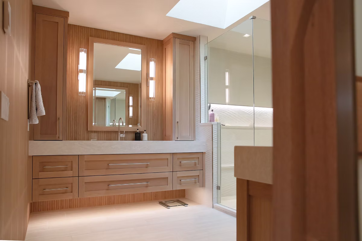Bathroom vanity with wood cabinetry and large mirror