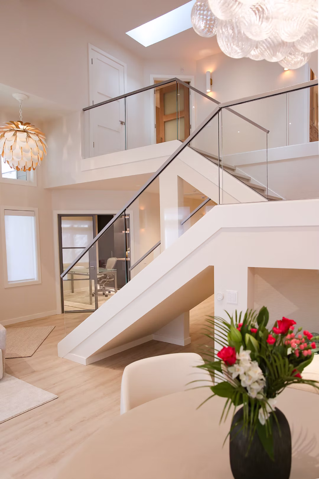 Modern staircase and living area with flowers in foreground