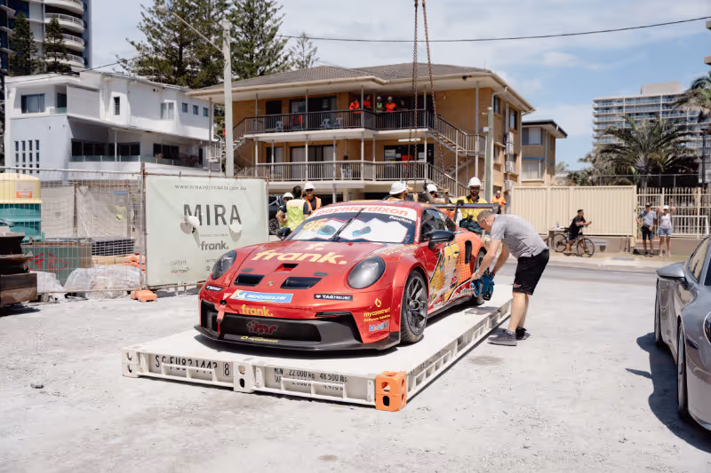 Crew members prepare to lift Brett Boulton’s Porsche GT3 Cup car at Frank Developments’ MIRA site on Northcliffe Beach.