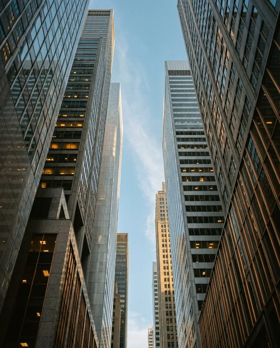 Tall office skyscrapers with glass windows reflecting the sky and light during daytime.