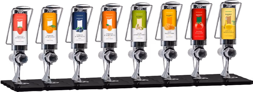 Line of nine stainless steel and glass dispensers filled with various fruit purees and syrups, each labeled with a different flavor.