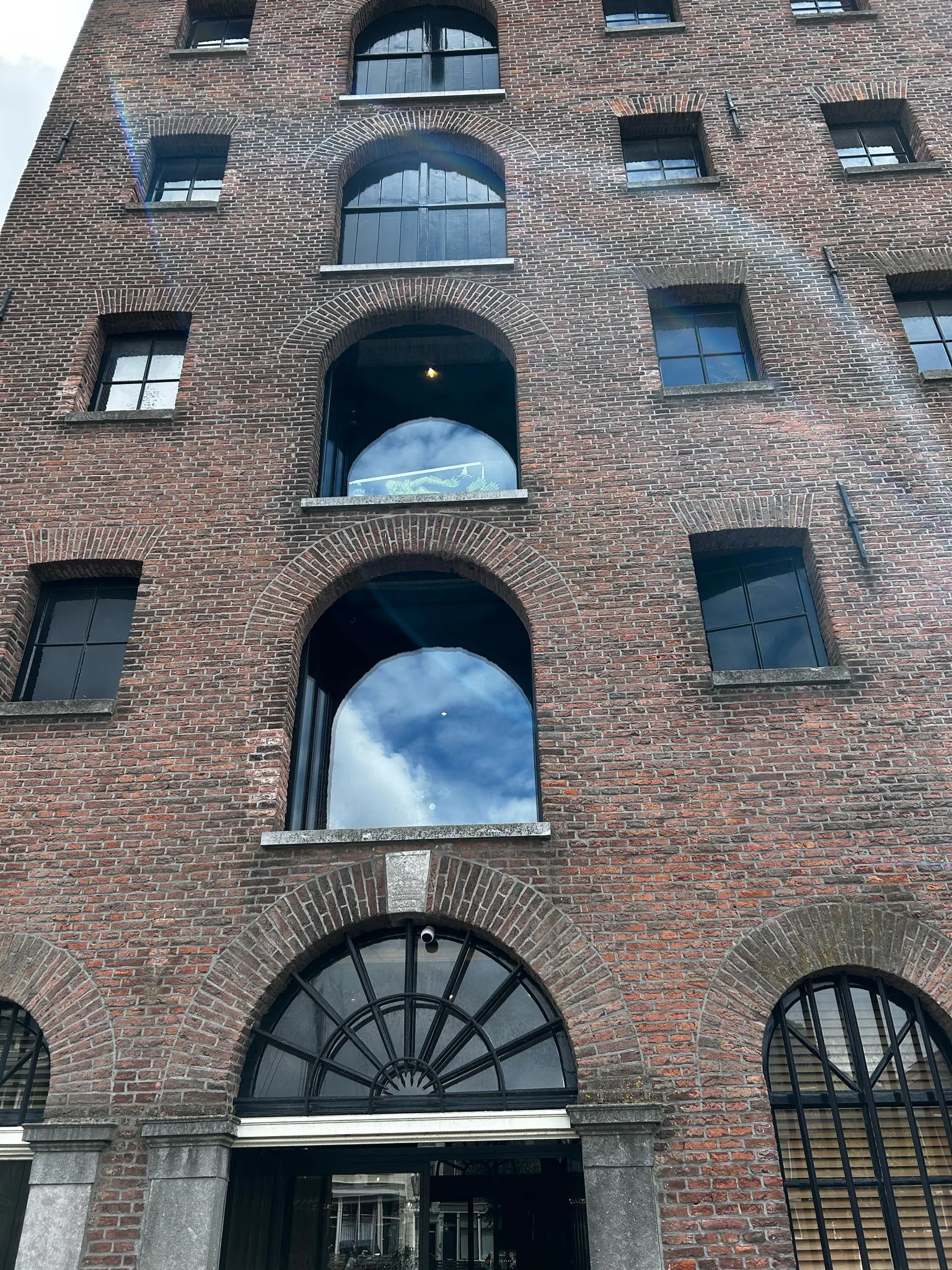 Voorgevel van De Dubbelde Palmboom met de nieuwe glazen etalages achter de historische luiken.