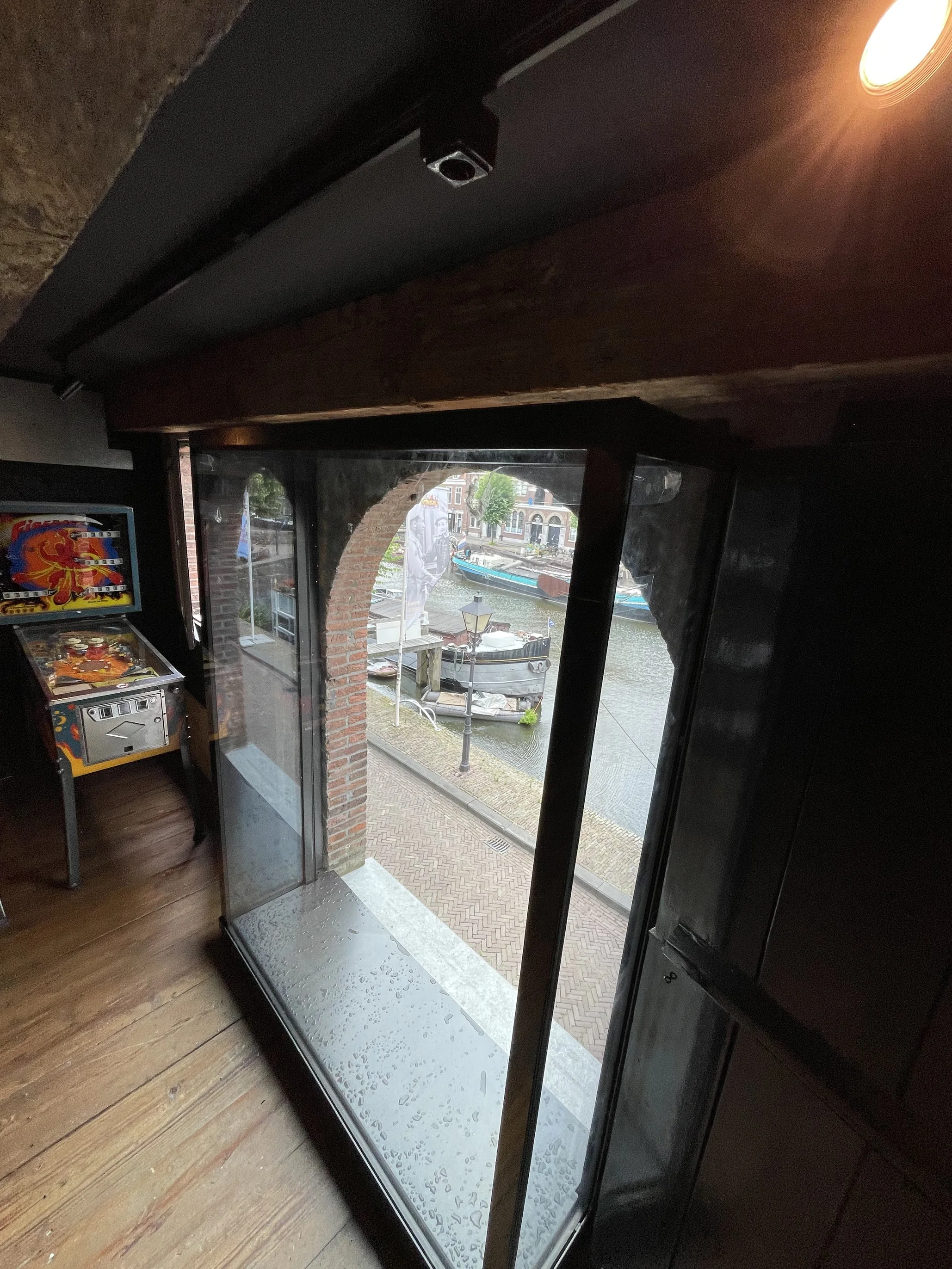 Glazen etalage aan de binnenzijde van het monumentale pakhuis, opgebouwd als transparant volume.