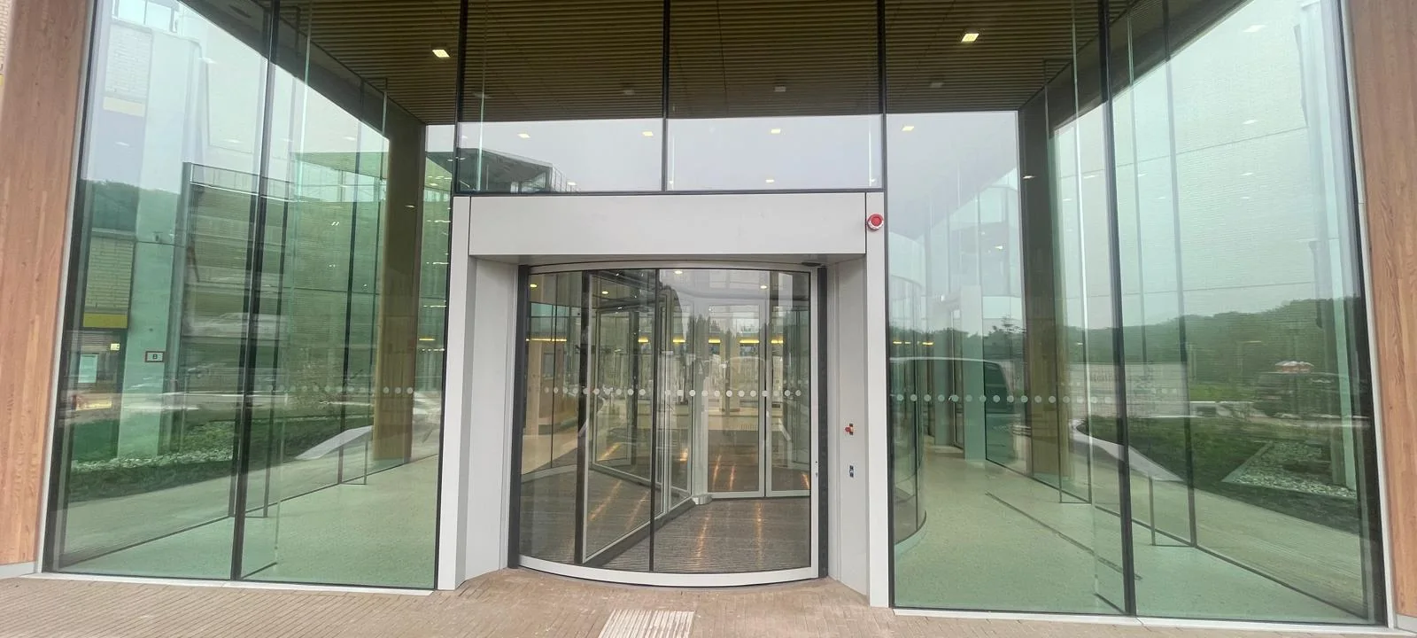 Transparante glazen entree van Rijnstate Arnhem onder de houten dakconstructie.