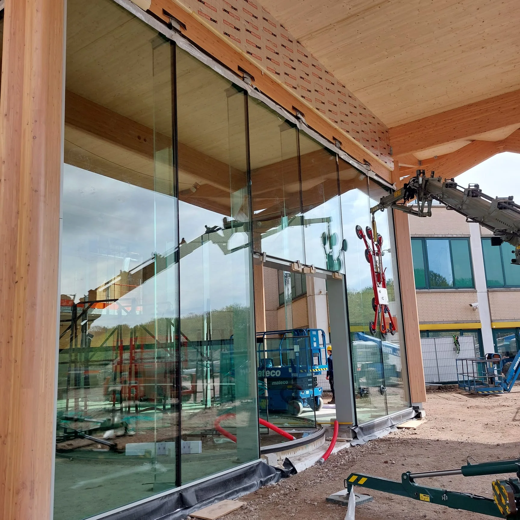 Montage van de grote glasgevel onder de houten entreeconstructie van Rijnstate.
