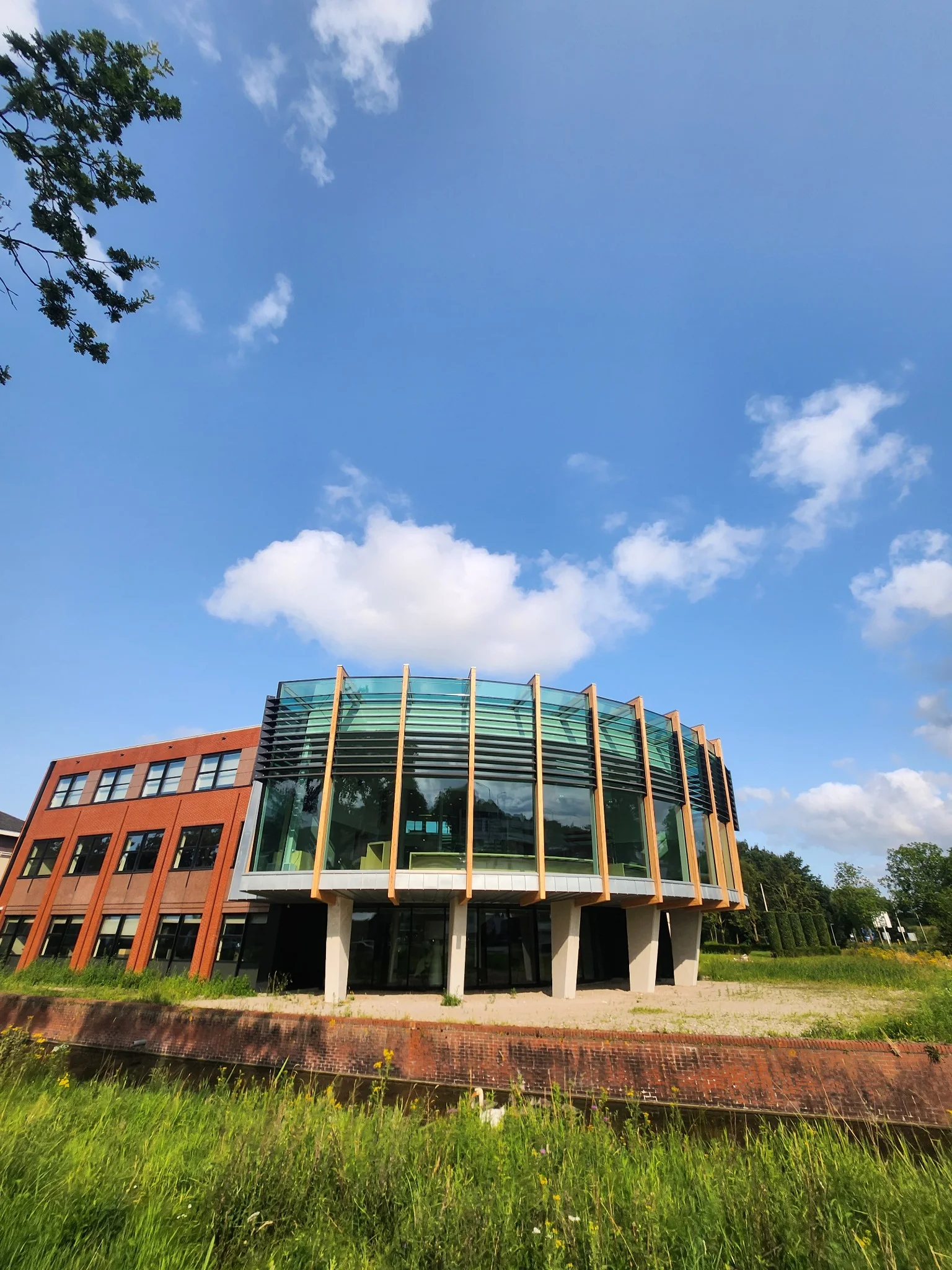 De glazen uitbreiding van het gemeentehuis aangesloten op de bestaande bouw.