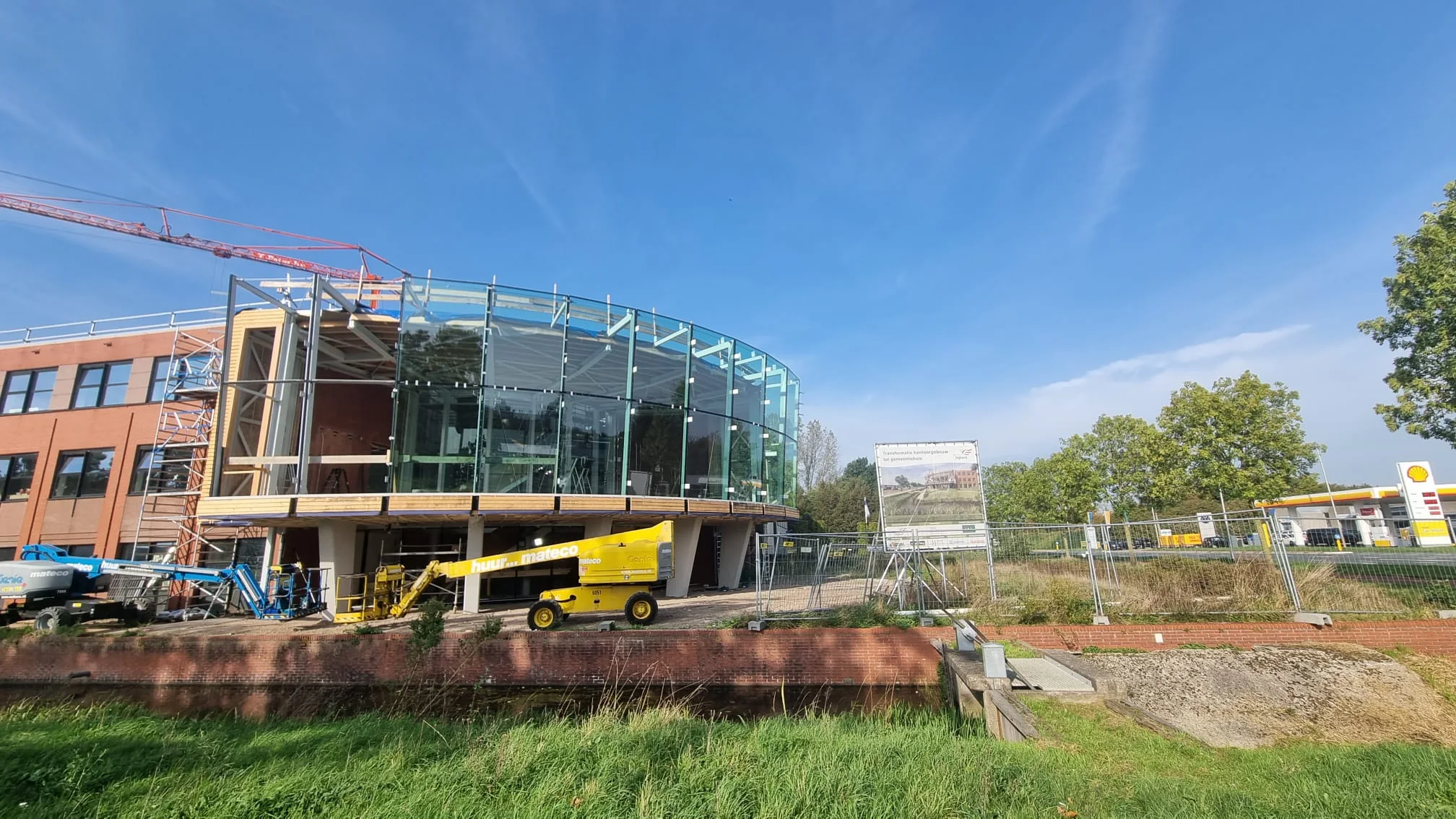 Montage van de grote glazen gevelpanelen van de uitbreiding van het gemeentehuis.