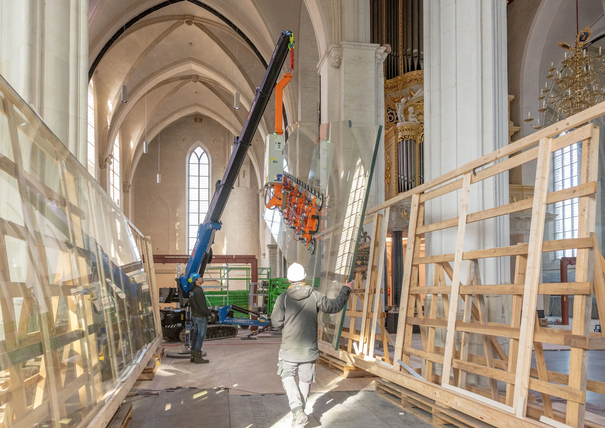 Een groot glaspaneel wordt met kraan en vacuümheffer opgericht in de Stevenskerk.