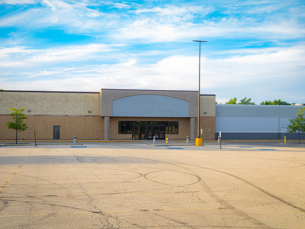 Kroger grocery store entrance with parked car and clear blue sky in the background.