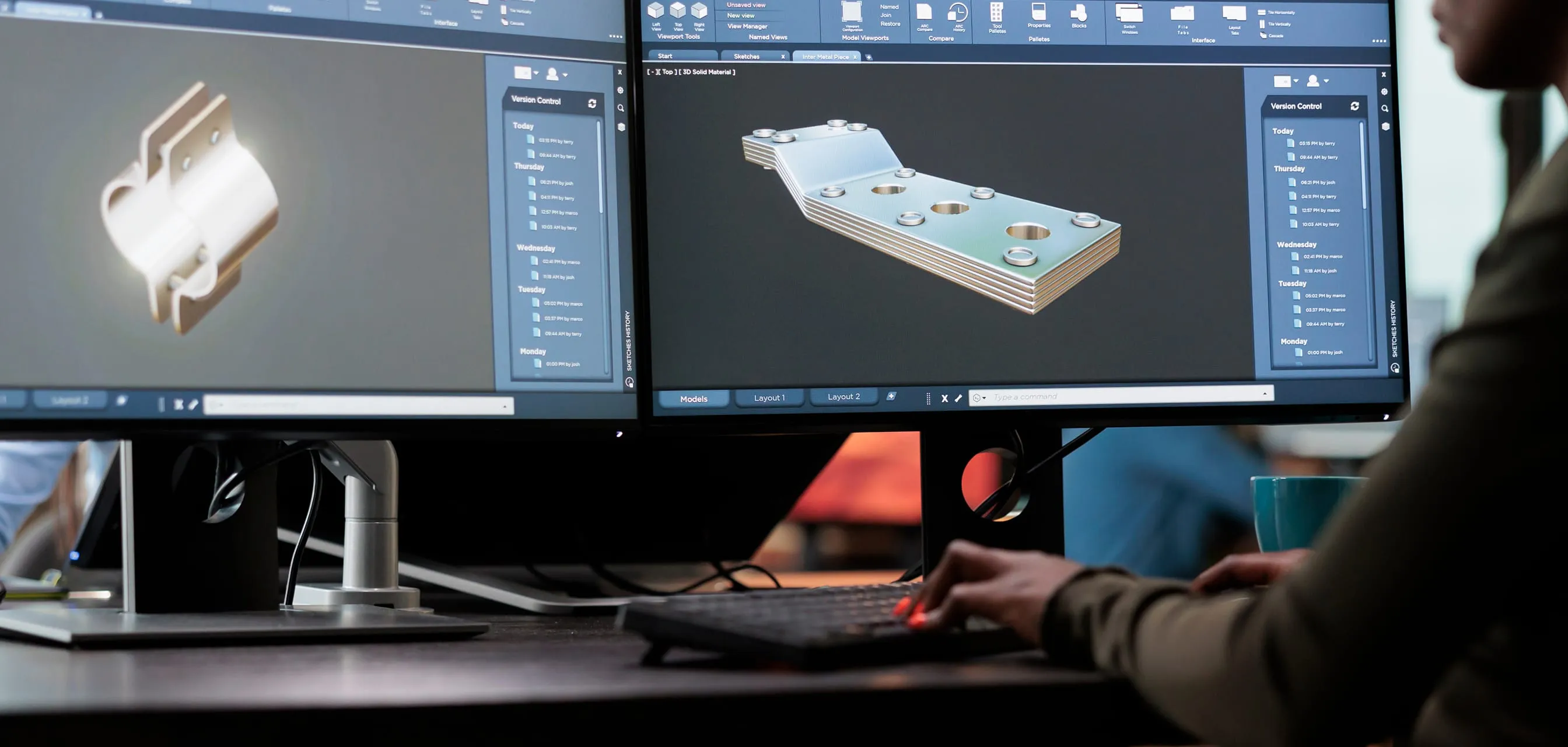 Person working on dual monitors displaying 3D CAD models of mechanical parts with version control panels on the screen.