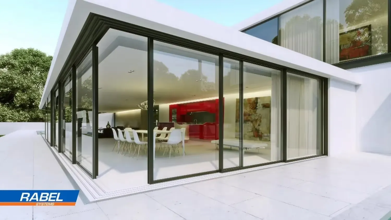 Modern house with floor-to-ceiling glass walls, showing a white dining table with chairs and a red kitchen inside.