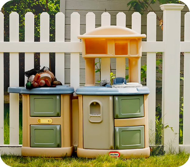 Children's playroom area with a toy kitchen set, blue baby seat, and a tall shelf filled with organized colorful toys and educational blocks next to foam climbing blocks.