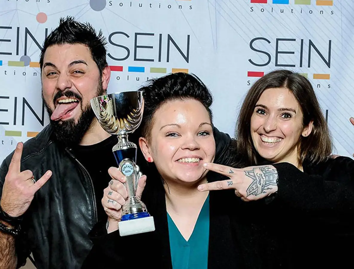 Kim Weber als Gewinnerin des SeinSolution Pitch – mit Pokal, Lorenzo Scibetta und Manja Feige beim Feiern