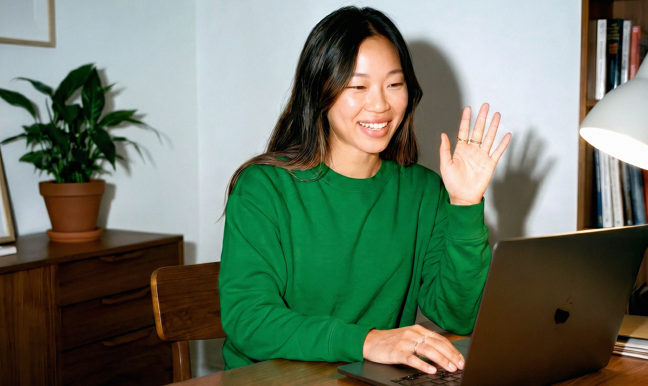 Three colleagues closely reviewing work together on a laptop