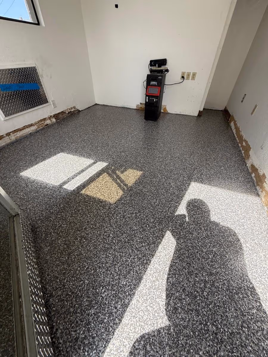 Gray flake floor in a small commercial room with a coved wall base and daylight across it