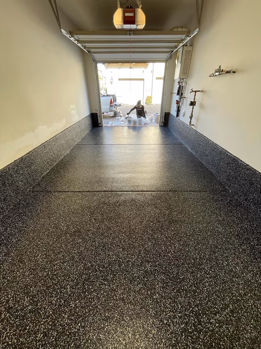 Epoxy flake garage floor seen from inside the garage with the door open