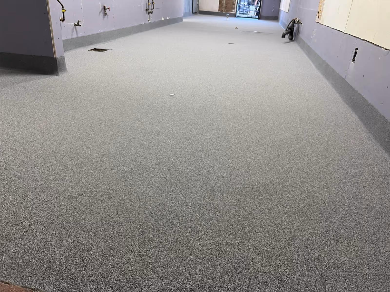 Light gray flake floor in a commercial back room with a coved wall base under fitted units