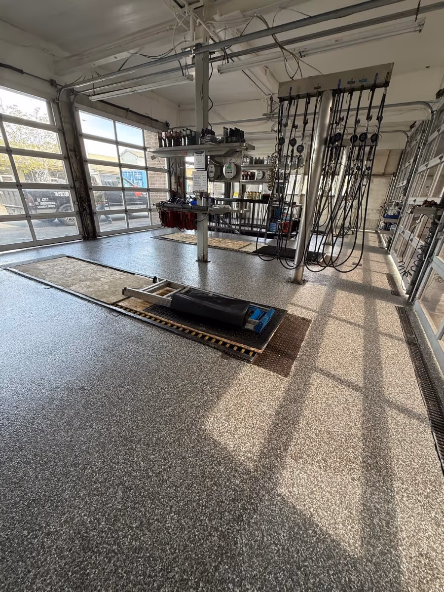 Flake floor through a vehicle workshop with glazed frontage and a lift