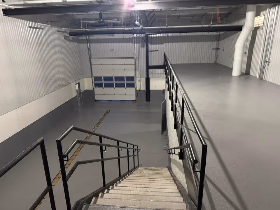 Urethane cement floor in a production area with steel stairs and a roll-up door