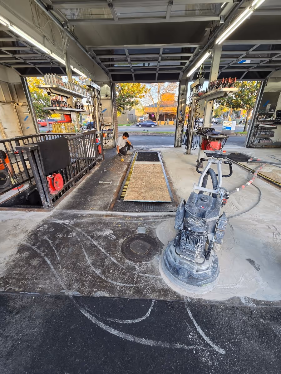 Planetary grinder preparing the concrete floor of an auto shop with the roller doors open