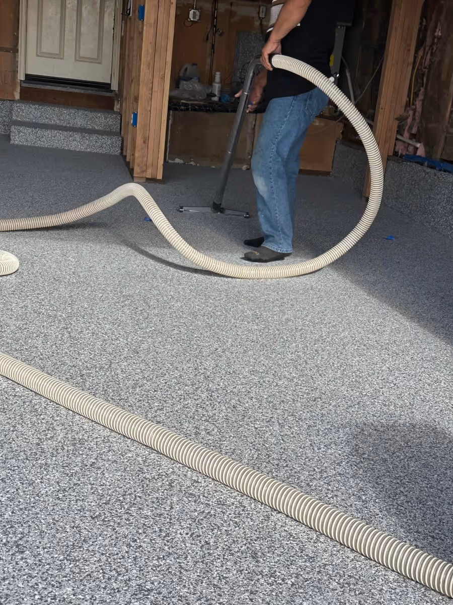 Installer moving a dust extraction hose across a garage floor