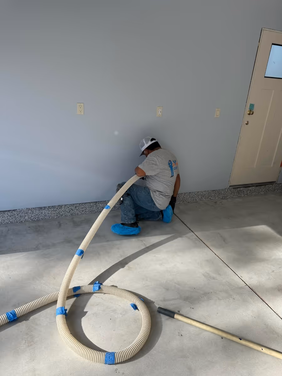 Installer applying a garage floor coating by hand