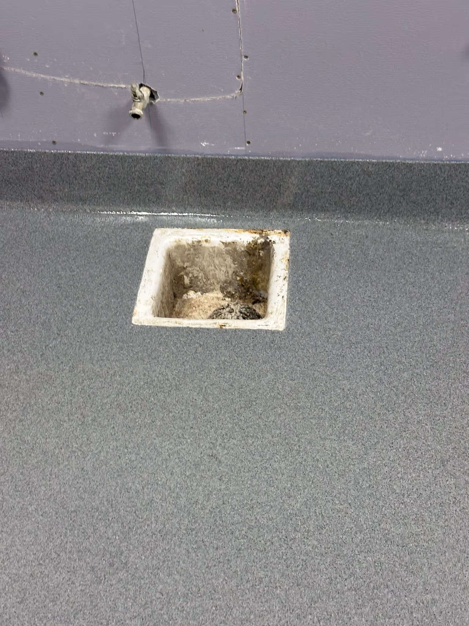 Floor drain set flush into a seamless quartz broadcast floor