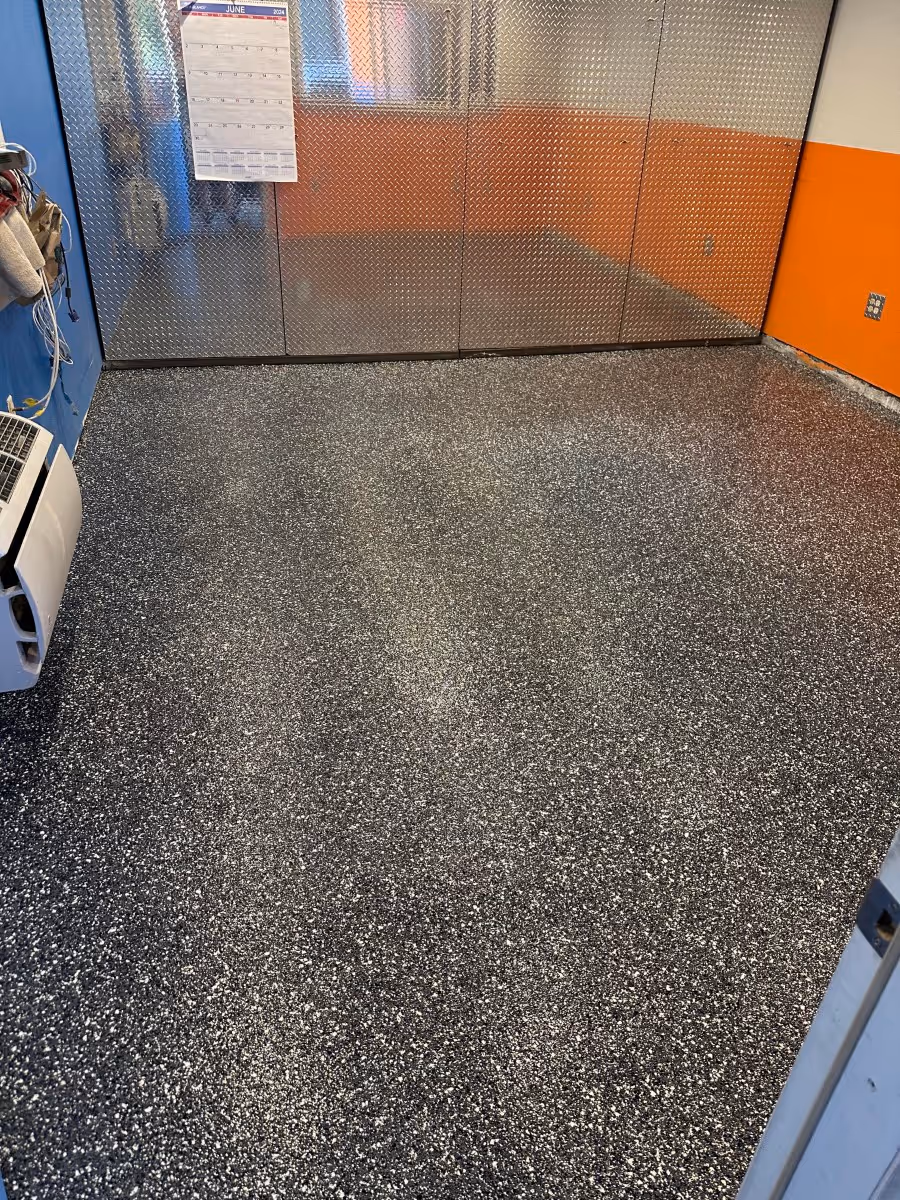 Dark flake floor in a garage workshop with metal storage cabinets along the back wall