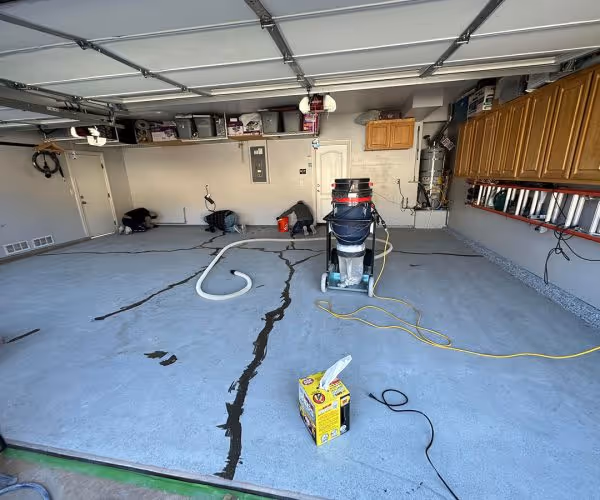 Garage slab being diamond ground with cracks routed before coating